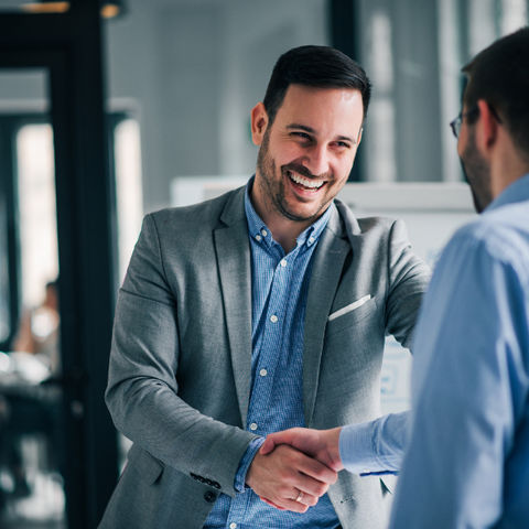 Two businessmen shaking hands and smiling