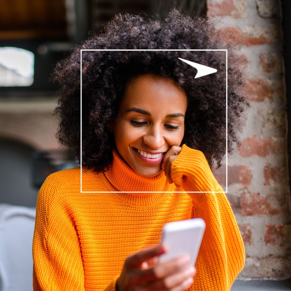 Woman smiling at phone in restaurant