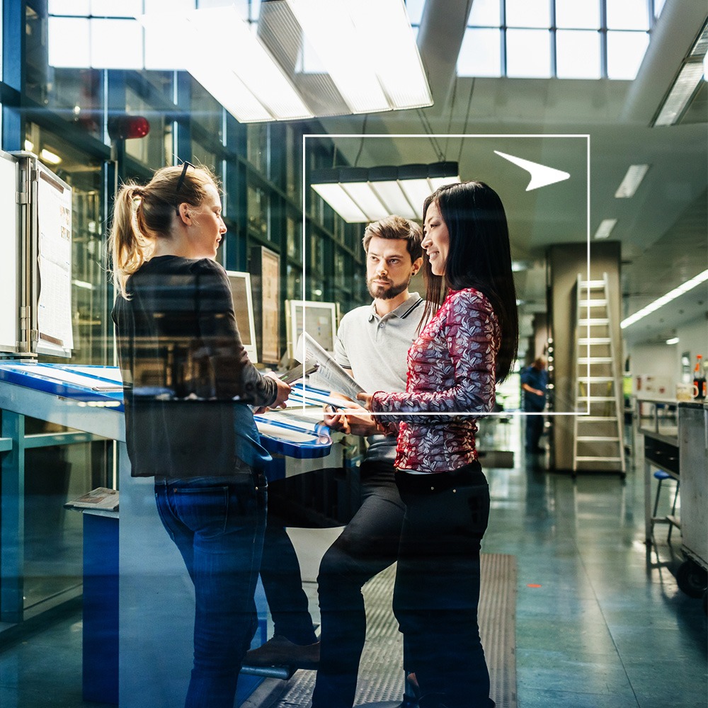 Three coworkers talking against industrial background