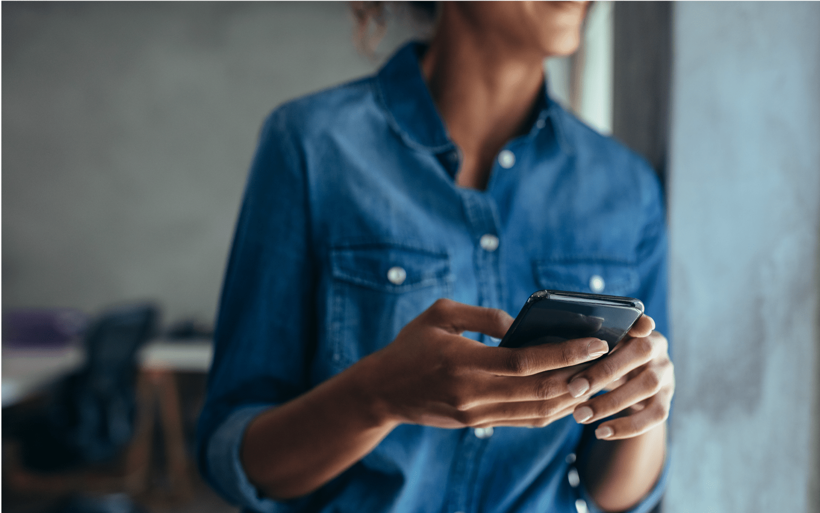 Shoulders and hands of woman holding phone