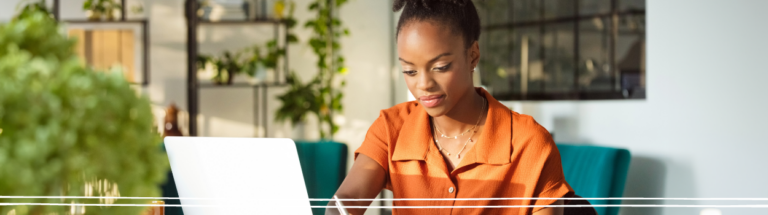 woman-looking-down-at-computer-in-orange