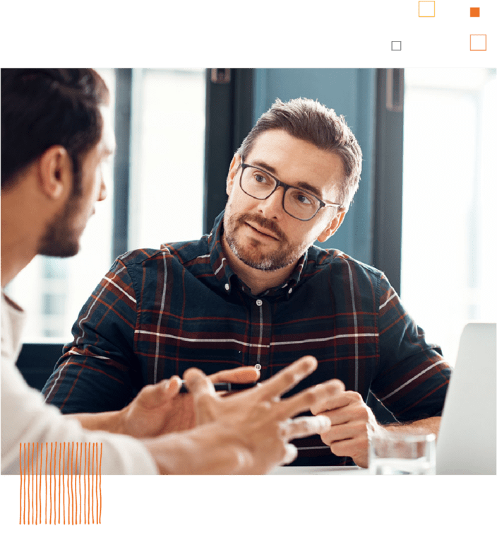 Two coworkers talking at table