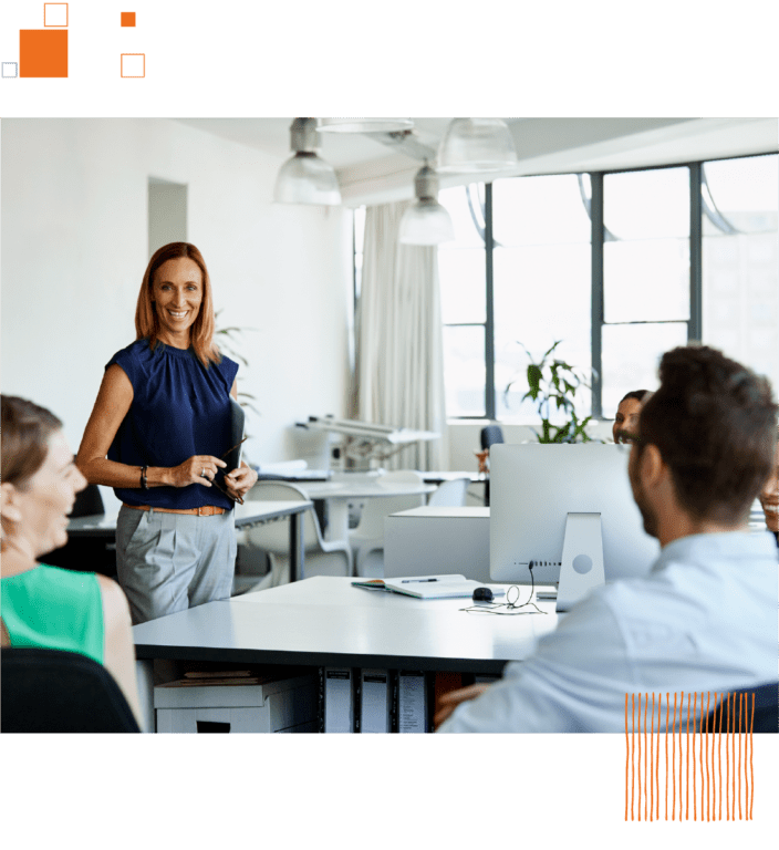 Woman talking to coworkers at desks in office