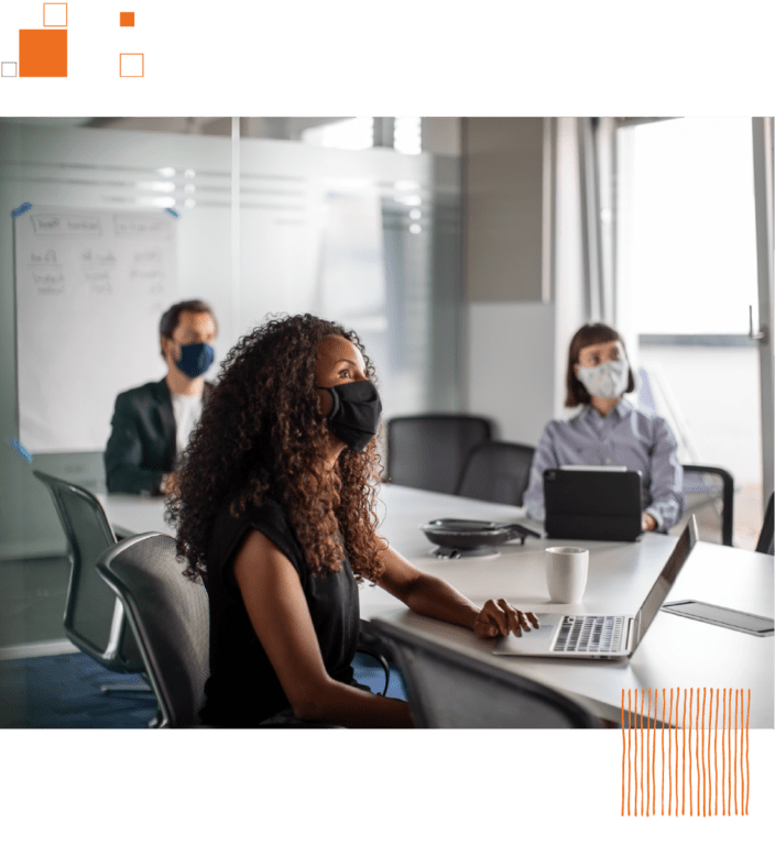 Coworkers at conference table in face masks