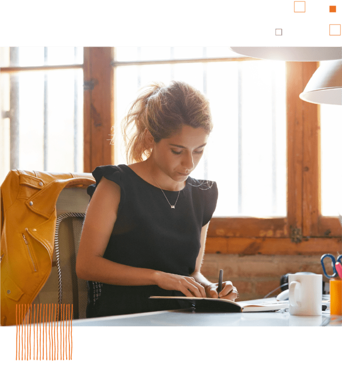 Woman writing in notebook at home