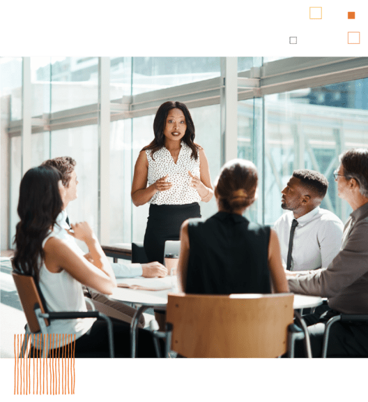 Woman presenting to table of coworkers