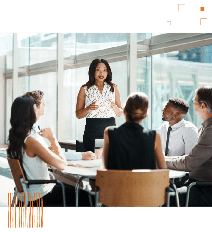 Woman presenting to table of coworkers