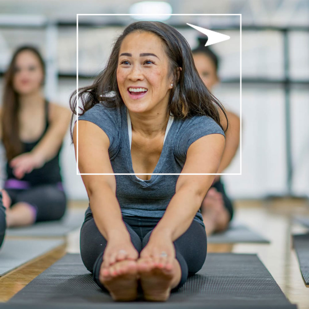 Woman stretching on yoga mat in workout class