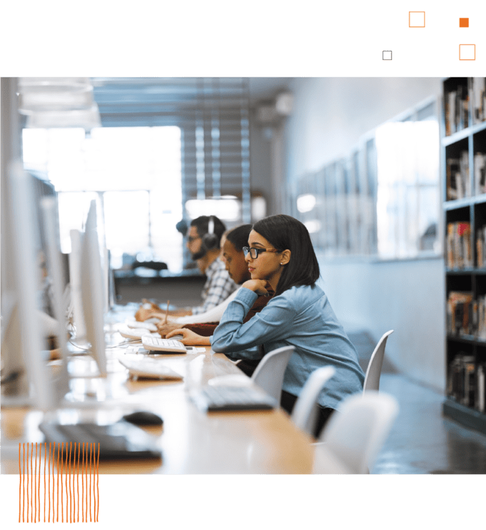 Woman sitting at row of computers in library