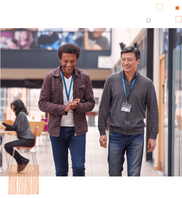 Two men walking in school hallway