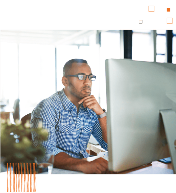 Man sitting at desk staring at desktop computer