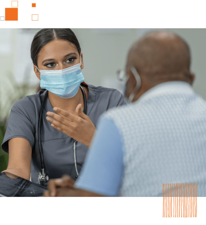 Healthcare worker in face mask showing tablet to male patient