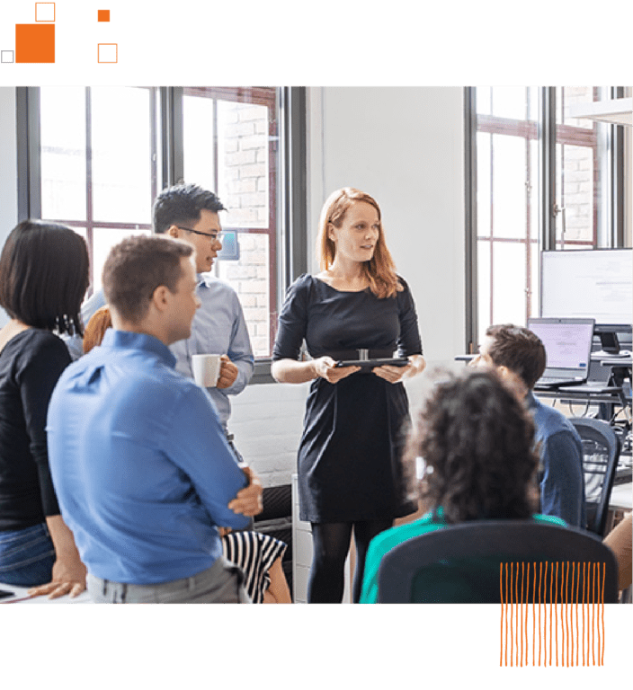 Group of co-workers talking in circle against office background