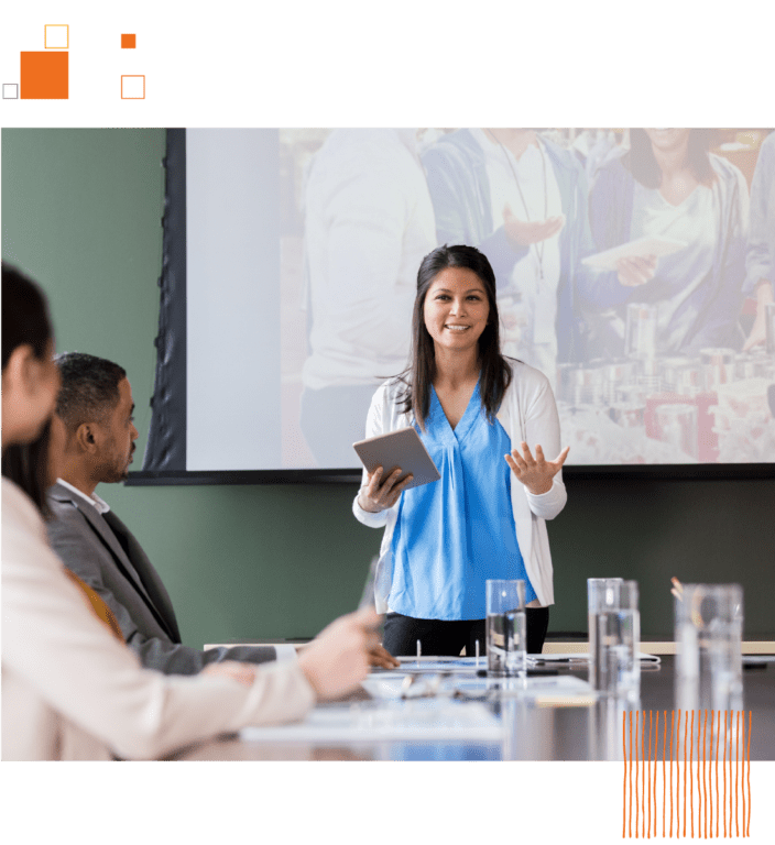 Woman presenting to coworkers in front of screen