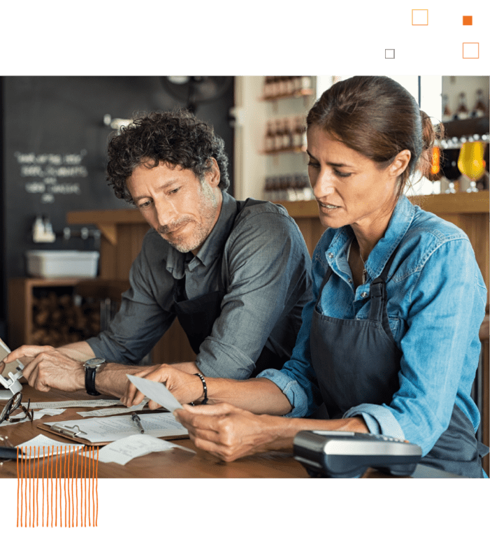 Man and woman looking over receipts with coffee shop background