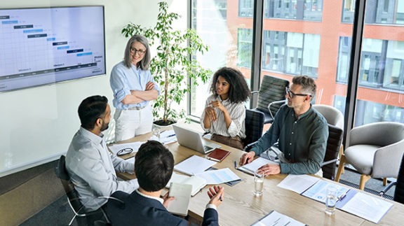 group of workers sitting t table in conference room