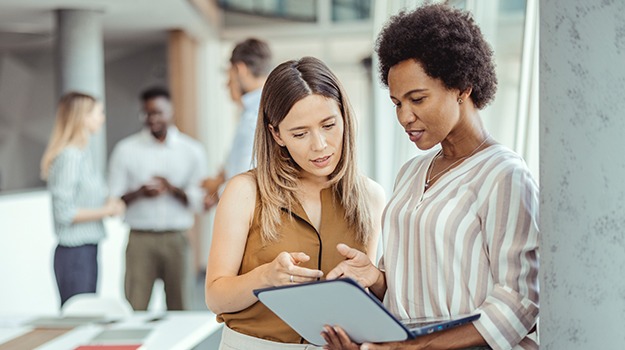 two workers looking at laptop in office