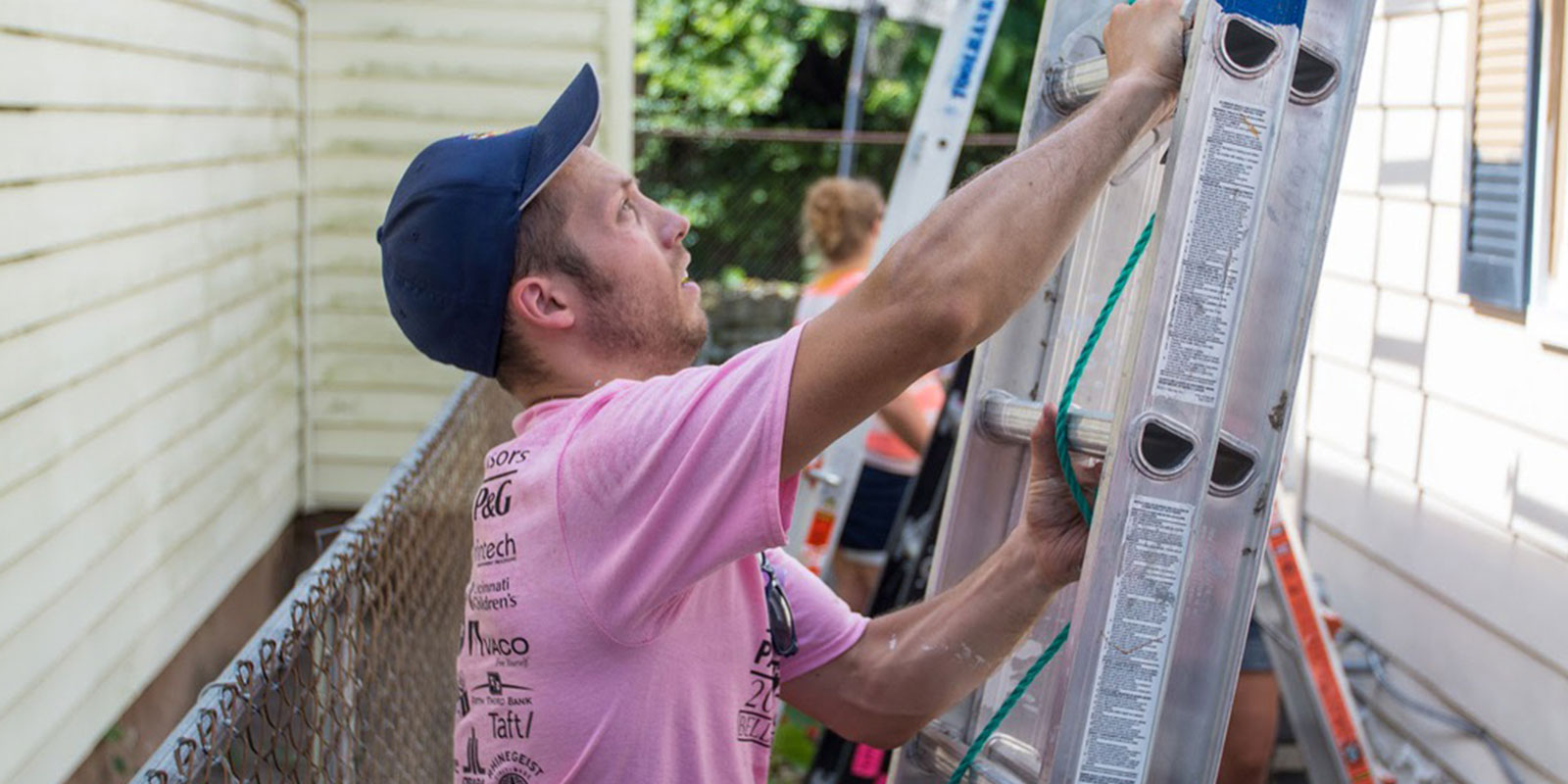 Paycor employee standing on ladder working for community service