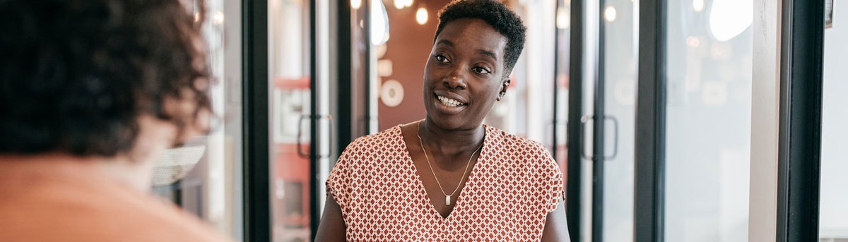 Woman sitting down and speaking with customer in a business setting