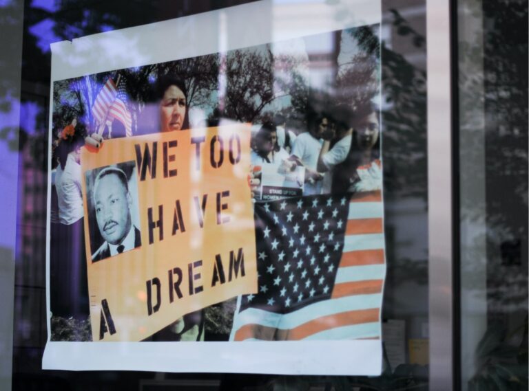 Photo of woman holding we have a dream poster in march march posted on window