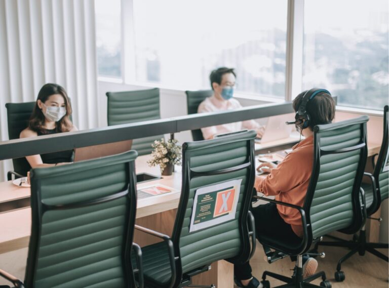 Employees at conference table wearing face masks