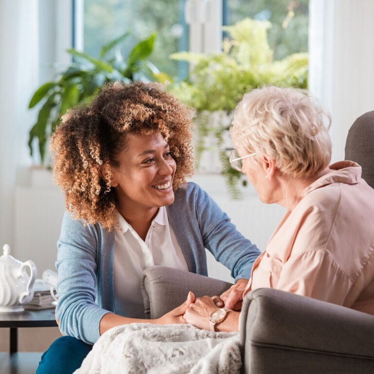 Woman talking to older woman in chair
