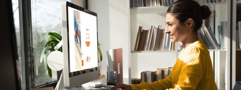 Female reading Paycor white paper on her laptop computer in home office