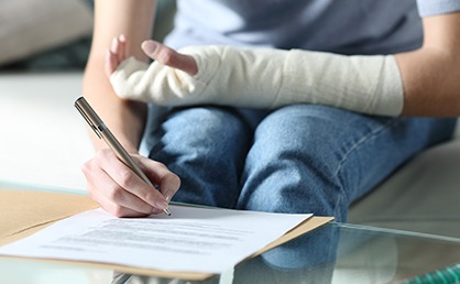 person with broken arm filling out paperwork