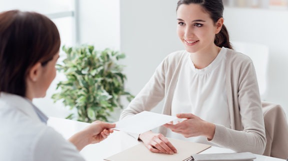 woman at desk accepting paperwork