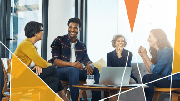 group of professionals sitting around a table talking and laughing