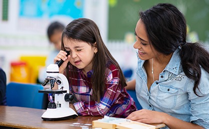 little girl using microscope