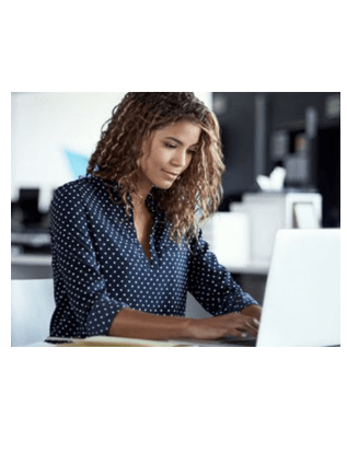 professional woman sitting at desk working on laptop