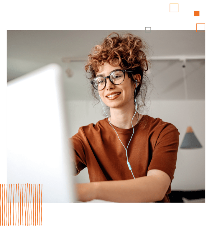 woman in glasses with ear buds in looking at computer screen.