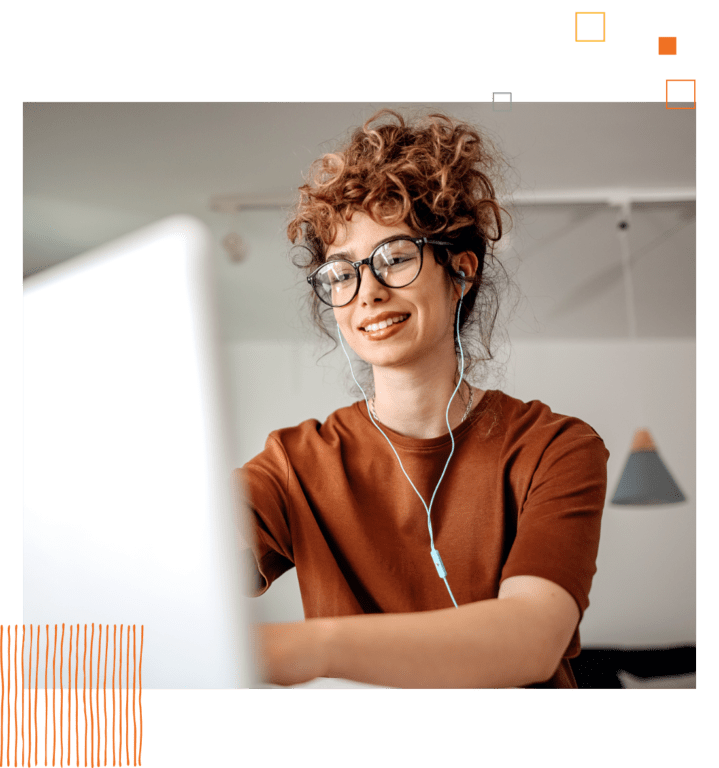 woman in glasses with ear buds in looking at computer screen. 