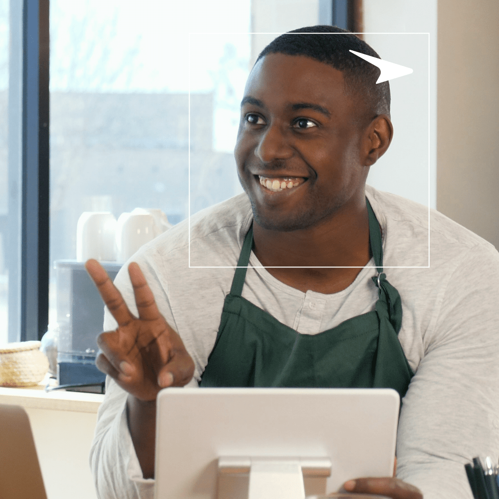 man with a green apron and a tablet