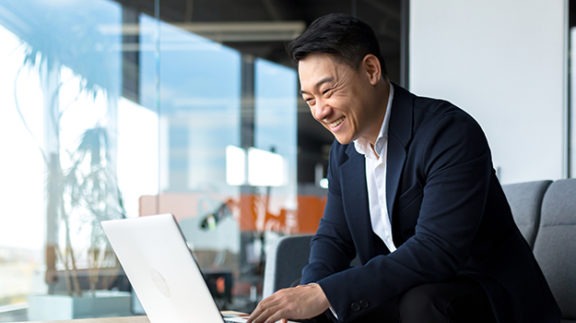 happy man in business suit using laptop