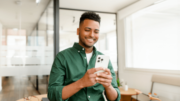 man-in-green-shirt-looking-at-a-cell-phone