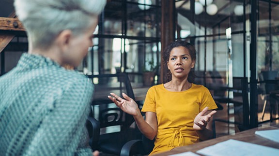 worker having conversation in conference room with coworker