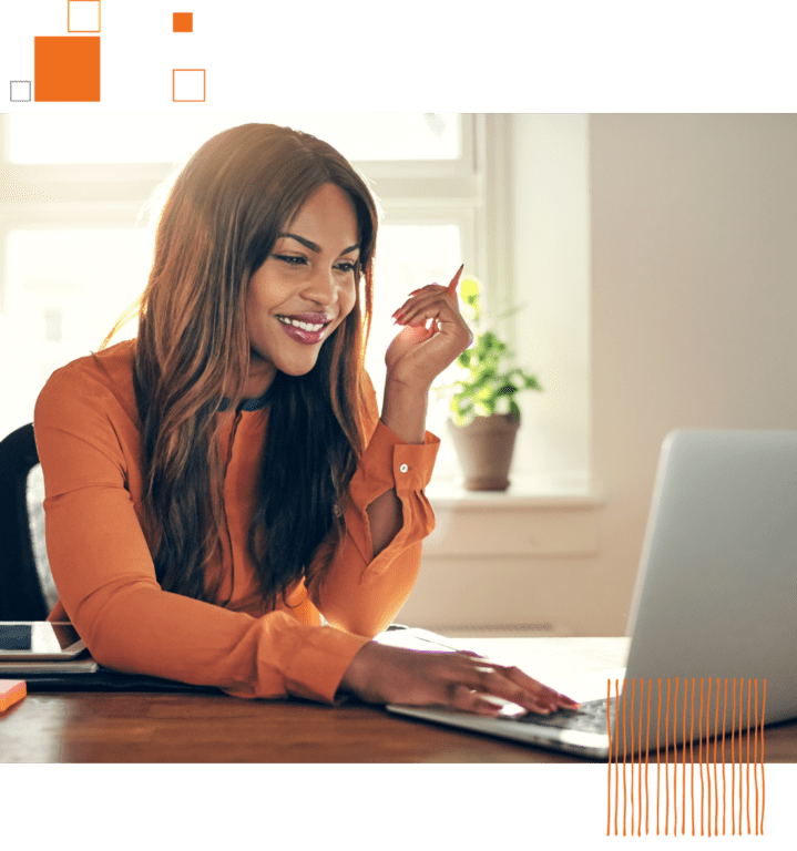 woman in orange working on a laptop