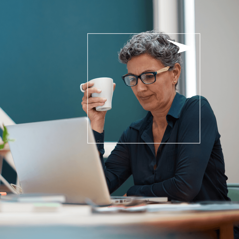woman working on laptop and holding cup