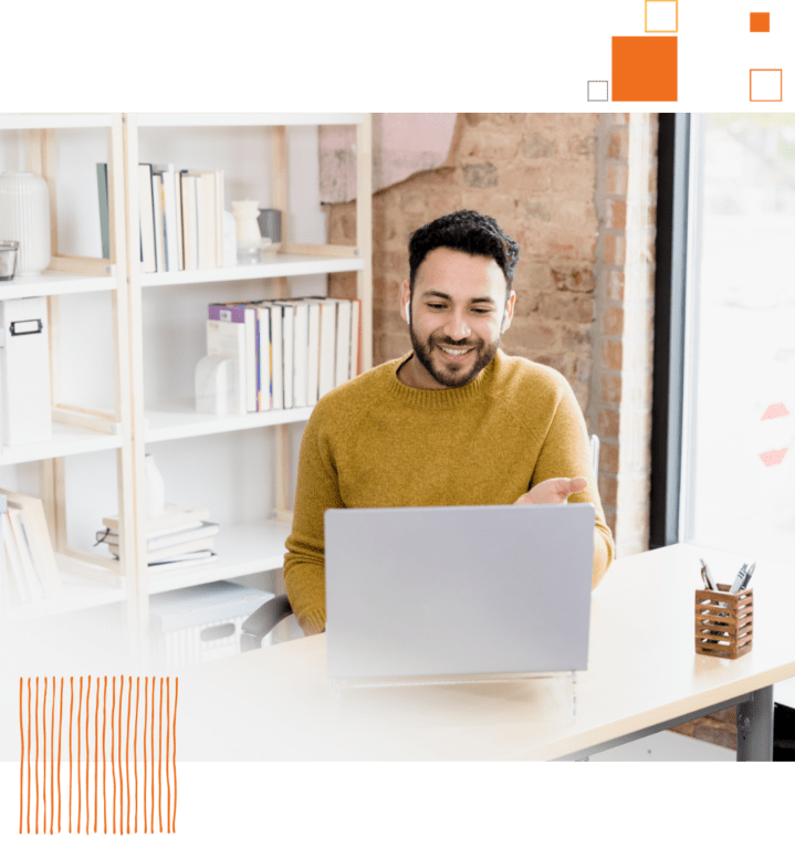 smiling man sitting in office using laptop