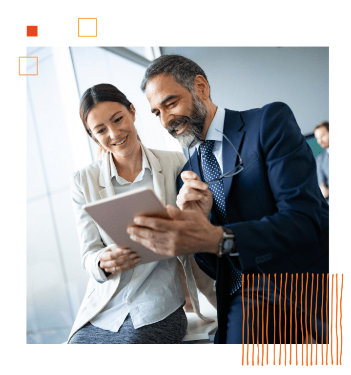 two coworkers holding and looking at tablet screen