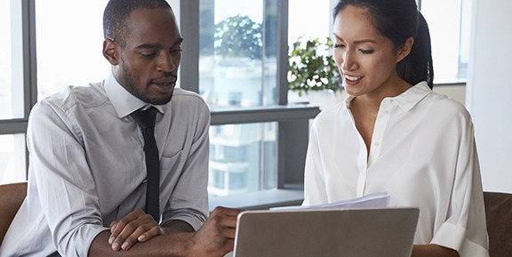 small business health care requirements man and woman sitting together looking at a laptop