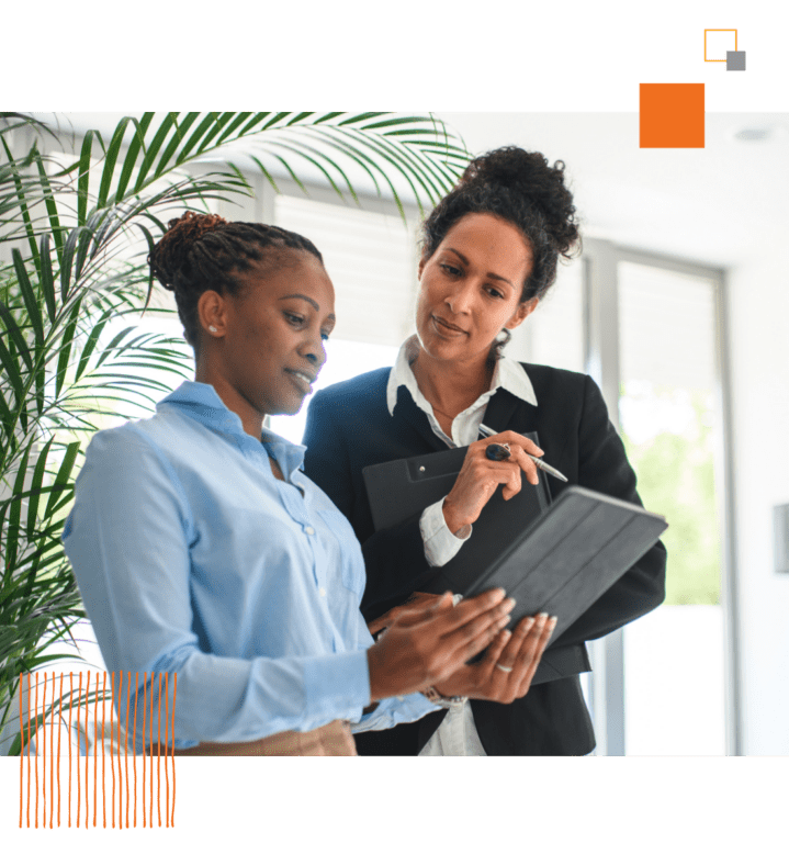 two women in office both looking at tablet