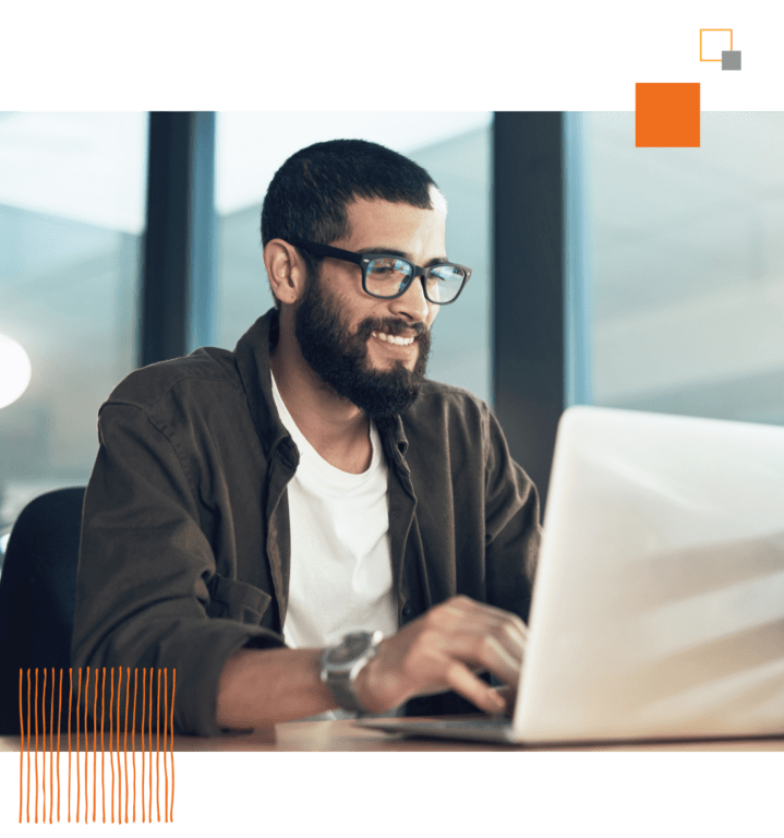 male worker smiling, typing on laptop