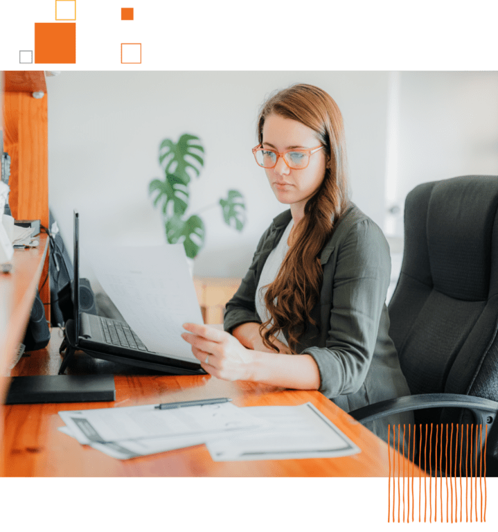 woman reading paper at desk in office