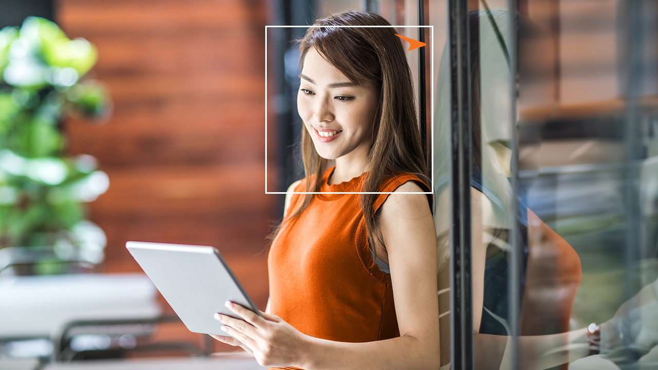 smiling woman looking at a tablet in her hand