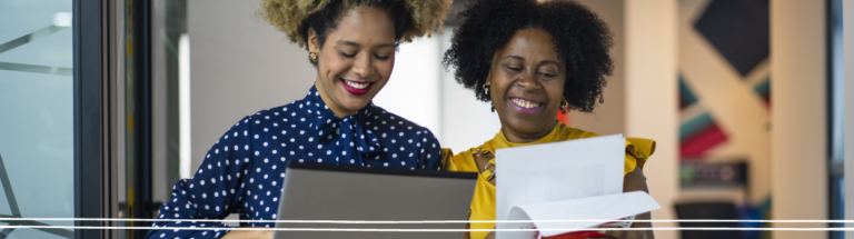 two-women-with-curly-hair-smiling-while-working