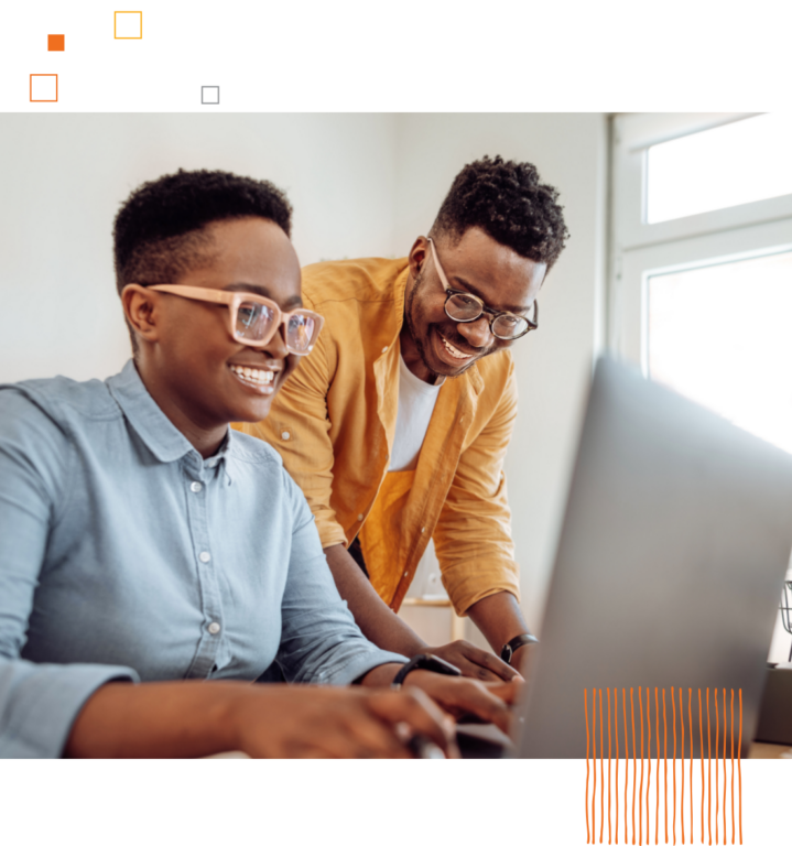 two smiling workers using a computer