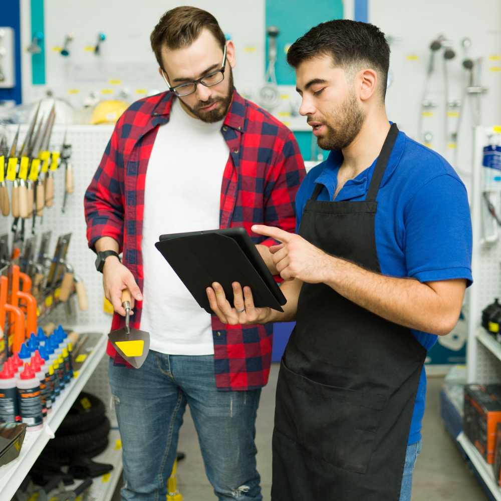 a worker and customer looking at a tablet in a hardware store